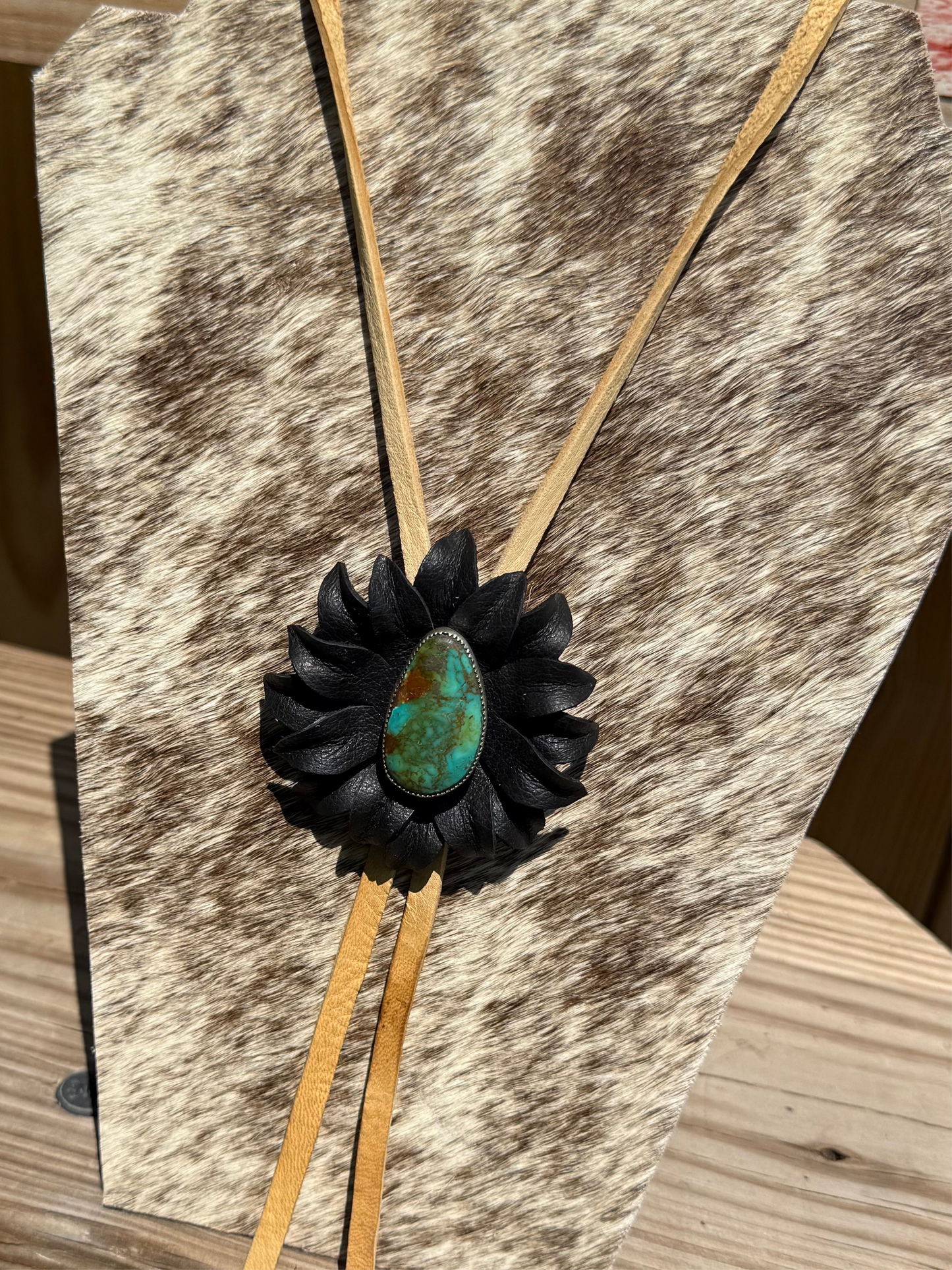 Genuine turquoise and sterling silver bolo, set with a leather flower